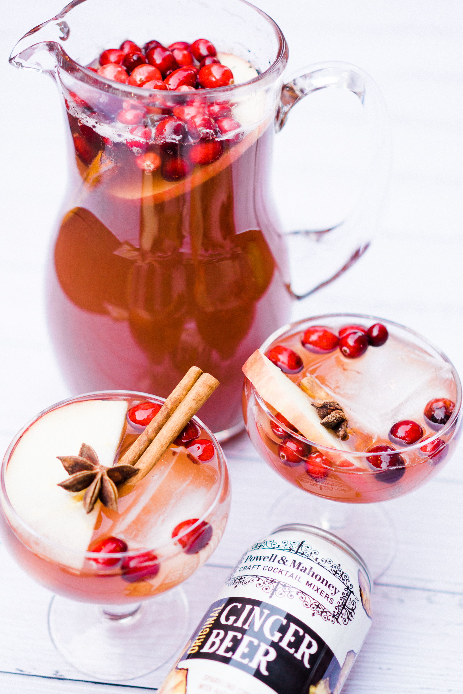 two glasses and a pitcher of Holiday Mocktail: Sparkling Vanilla Ginger Apple Cider Holiday Punch